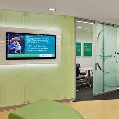 Entrance to a conference room at Citizen's Bank, with frosted glass doors and light green walls behind an LCD television.