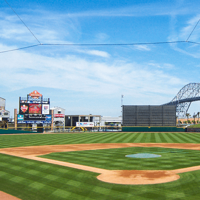 Home plate view of the Corpus Christi Hooks baseball team at Whataburger Field. Bright green grass surrounds a minor-league baseball diamond.