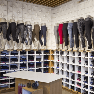 Bright white corner of a Lululemon store with many mannequin legs showcasing Lululemon leggings. Mannequins of legs surround new leggings.